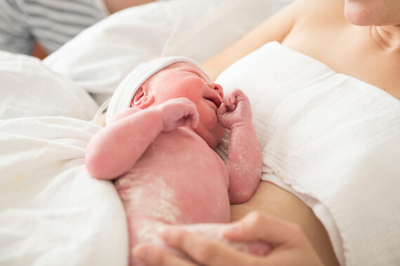 Pas geboren baby bij moeder op de buik