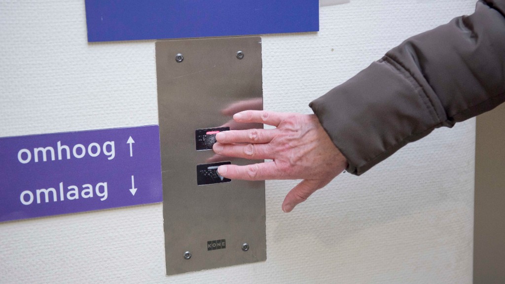 hand drukt op knop in lift