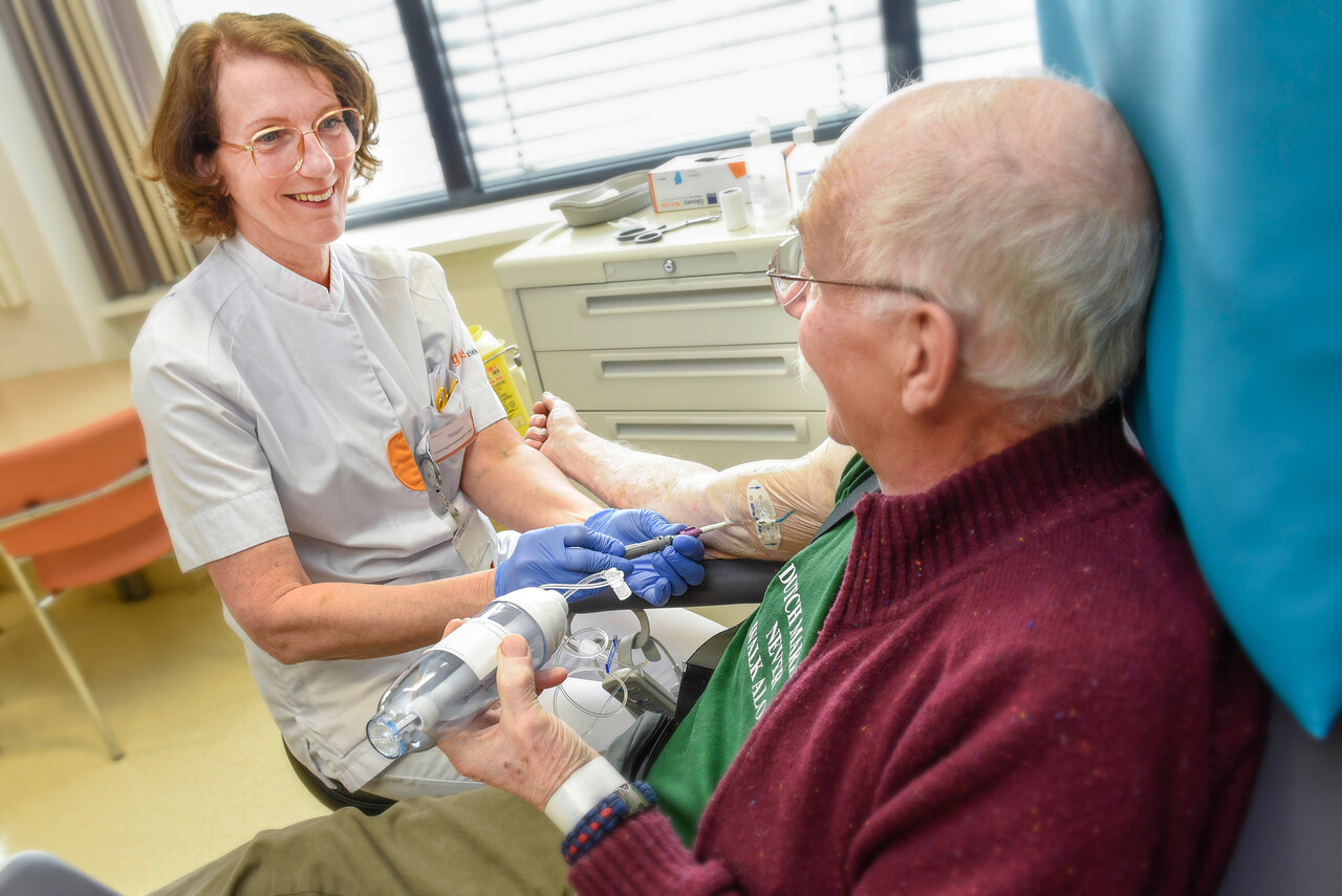 Oncologie verpleegkundige sluit patiënt aan op draagbare infuuspomp met chemotherapie