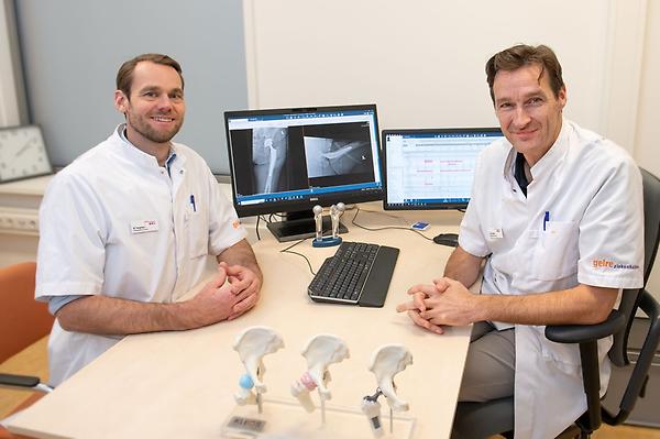 Twee orthopedisch chirurgen laten een aantal protheses zien