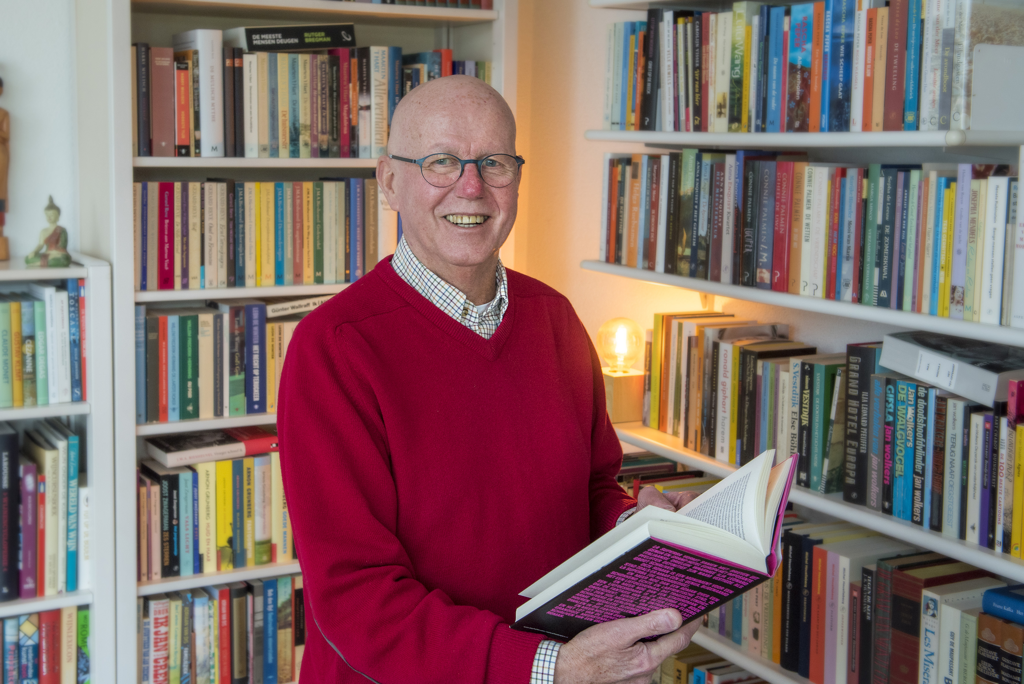 De heer Klomp thuis voor zijn boekenkast