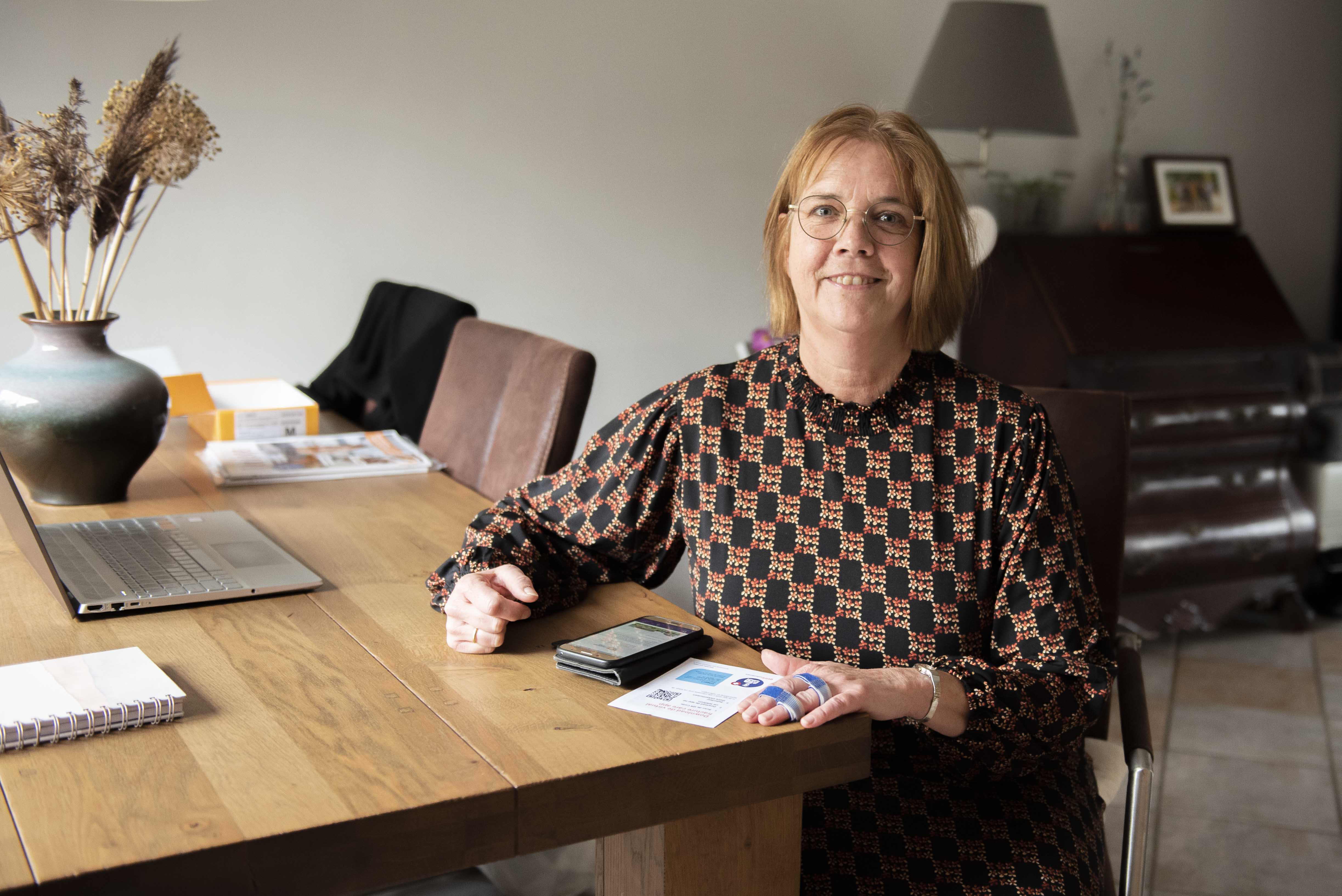 Alberdien Dijkshoorn zit thuis aan haar tafel en bekijkt de virtual fracture care app