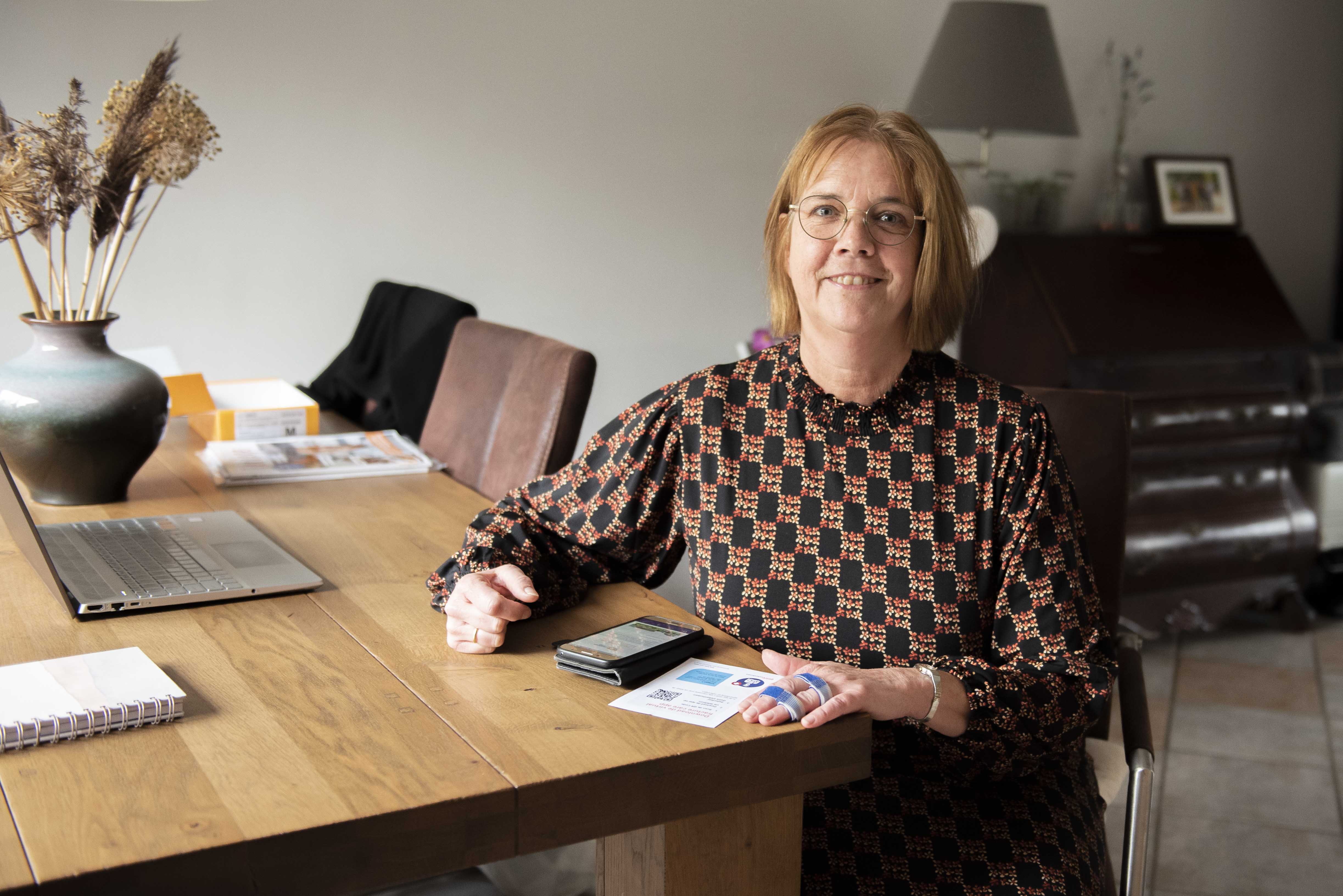 Alberdien Dijkshoorn zit thuis aan haar tafel en bekijkt de virtual fracture care app