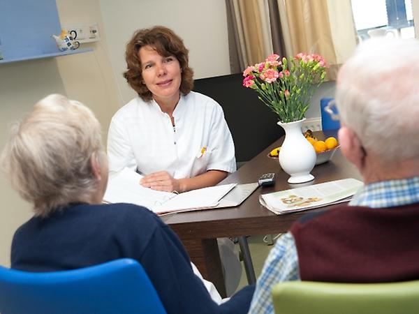 Arts in gesprek met twee oudere patienten