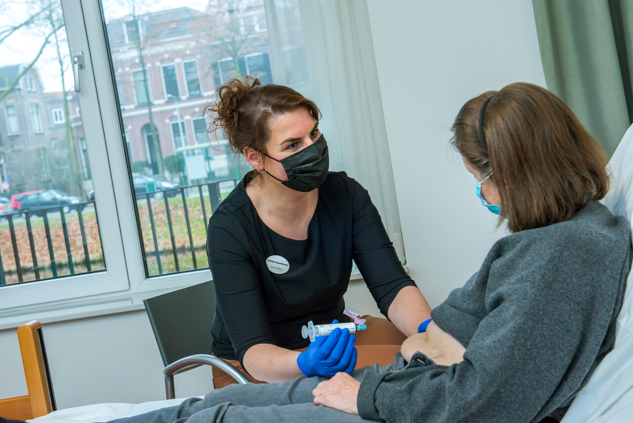 Patiënt krijgt chemotherapie injectie van gespecialiseerd verpleegkundige in de wijklocatie van Sensire